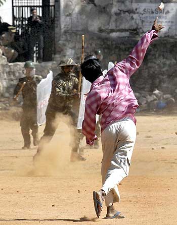 A pro-Telangana supporter throws a a brick at police during a protest in Hyderabad