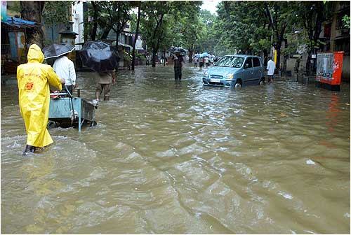 A municipal  worker at work on a flooded street