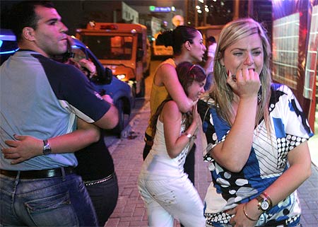 Local residents react near the scene of a rocket attack in the southern Israeli town of Sderot
