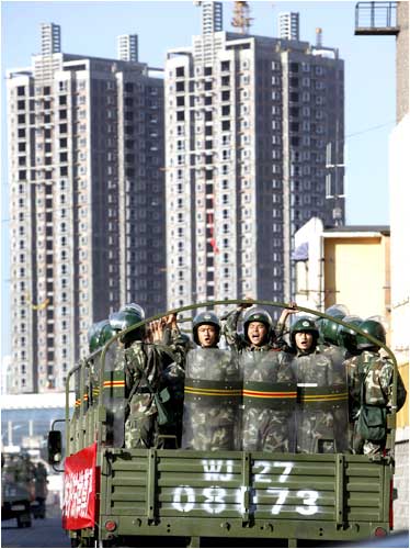 Chinese troops shout slogans as they ride a truck on the main street of Urumqi