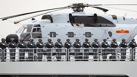 Chinese Marines stand at attention on a warship while taking part in an international fleet review to celebrate the 60th anniversary of the founding of the People's Liberation Army Navy in Qingdao, Shandong province