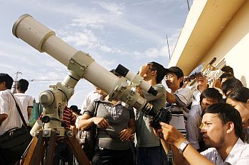 A scientist takes a photo of the eclipse through a telescope