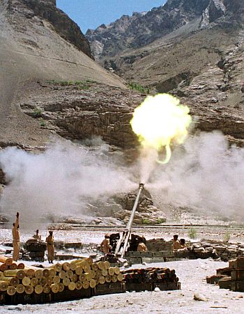 Pakistan army soldiers fire an artillery piece from a post in Kharmang district, close to the cesefire line, towards Indian army positions in Drass sector