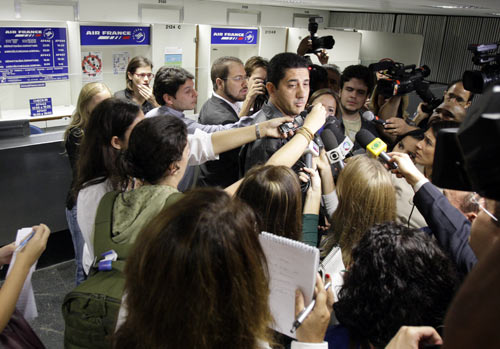 Journalists interview a relative of Air France flight AF447 passenger at the Tom Jobim International airport in Rio de Janeiro