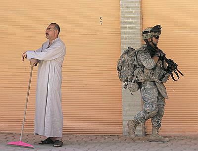 A US soldier walks past a resident during a patrol in Samarra