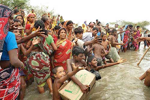 Homeless villagers reach out for aid material in Khulna, Sunderbans
