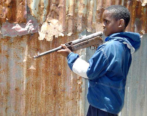 A boy plays with a gun at a village in Somalia's capital Mogadishu