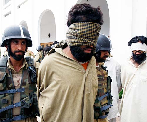 Soldiers take away a blindfolded suspected militant after showing him to the media in Lower Dir district in Swat region