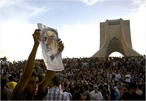 A demonstrator holds up a picture of Mousavi during the rally