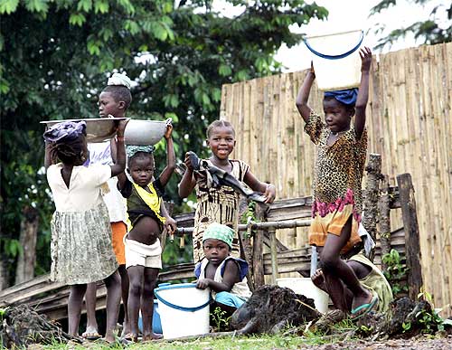 Liberian refugees gather around a water well in a refugee camp in Tobonda, near Kenema in Sierra Leone