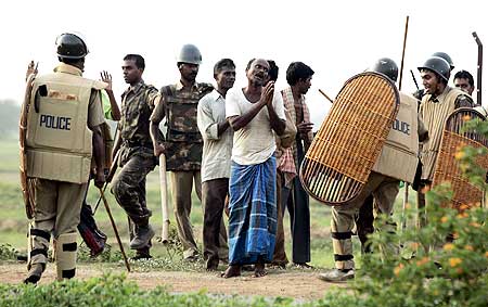 A villager begs a policeman to spare him after his arrest near Lalgarh