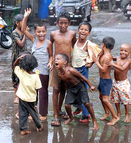 Children dance in the street as the first monsoon showers hit Mumbai
