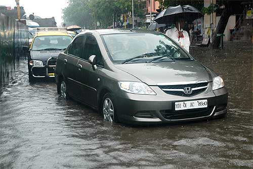 Vehicles navigate through a flooded street