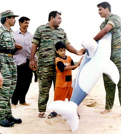 An undated photograph supplied by the Sri Lankan Ministry of Defence shows LTTE leader Prabhakaran playing with his son Balachandran as soldiers from the LTTE watch