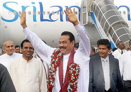 Sri Lankan President Mahinda Rajapaksa waves after disembarking his airplane at Colombo airport