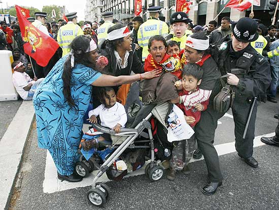 Pro-Tamil demonstrators scuffle with police after blocking a road in front of the Houses of Parliament in London