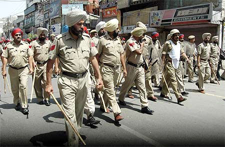 Policemen patrol a street in Amritsar