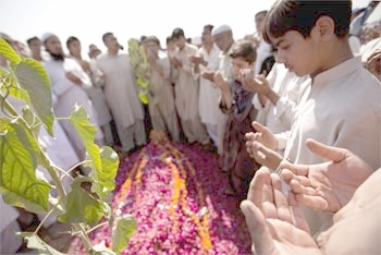 Family members pray over the grave of Sidra Khalid, who was killed in the Islamabad university blast
