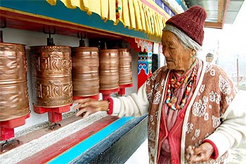 An elderly lady of the Manpa tribe spins prayer wheels at a monastery in Tawang, Arunachal Pradesh