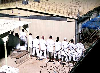 Detainees participate in a prayer session at Camp IV in Guantanamo Bay