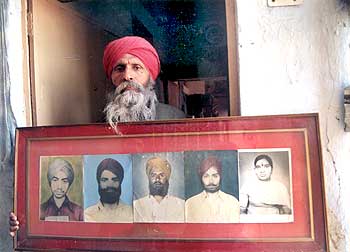 A file picture of a victim with a photograph of relatives lost in the 1984 riots.