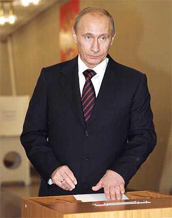 Russian Prime Minister Vladimir Putin drops his ballot into a ballot box at a polling station in Moscow.