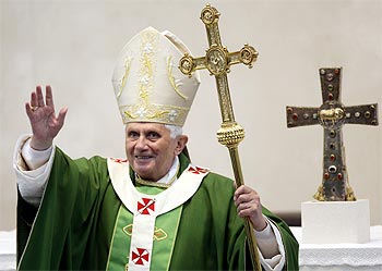 Pope Benedict XVI holds a cross as he waves after a mass in Brescia,Italy