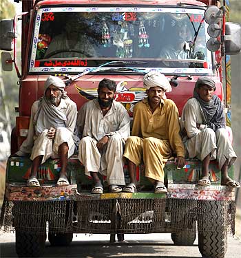 Labourers travel through a distribution point for internally displaced persons in Dera Ismail Khan