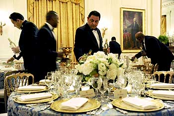 Waiters pour wine in the candle-lit East Room before US President Barack Obama plays host to congressional committee chairmen for a dinner at the White House