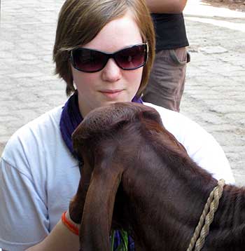 Naomi plays with a calf during her trip to India.