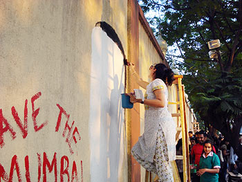 Another participant paints the wall