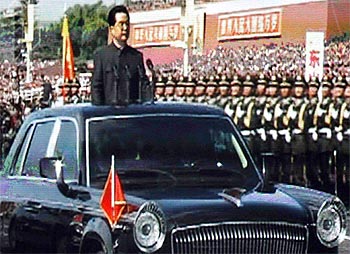A giant screen shows China's President Hu Jintao reviewing soldiers at the parade