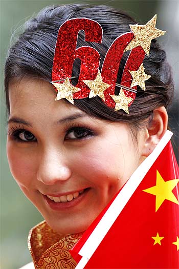 A model holds a national flag of China outside a shopping mall in Beijing
