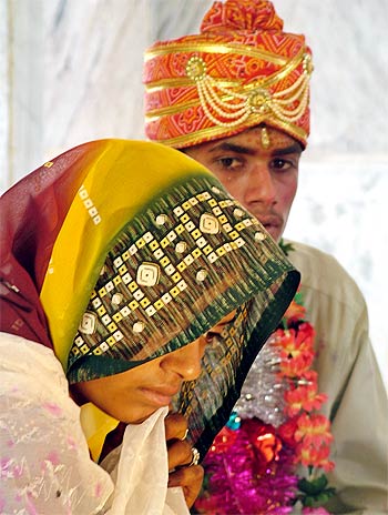 An under-age couple sit in a temple during their marriage ceremony at a temple near Bhopal