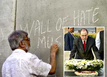 (Left) Arun Gandhi, the grandson of Mahatma Gandhi, writes graffiti on the concrete wall, part of the controversial Israeli security barrier, near the West Bank town of Tulkarm on August 28, 2004. (Right) Then Israeli Foreign Minister Silvan Shalom places a wreath at the Mahatma Gandhi memorial at Rajghat in New Delhi on February 11, 2004.