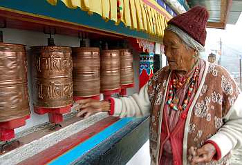 An elderly woman belonging to the Manpa tribe spins the prayer wheels at a monastery in Tawang