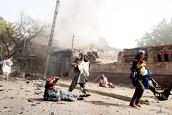 Locals flee the scene of suicide attack on the Indian embassy in Kabul on July 7, 2008