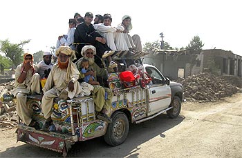 Residents fleeing the military offensive against Taliban in South Waziristan pack a vehicle while going through Bannu