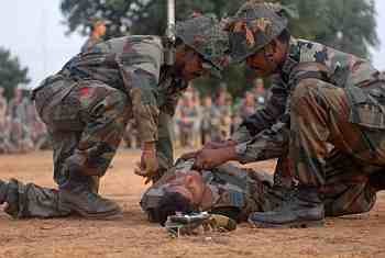 Indian soldiers offer medical assistance to an injured colleague during a simulated exercise