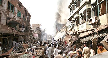 Residents, rescue workers and security officials gather at the blast site