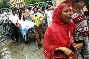 A hospital worker and relatives bring out the body of Lalita, a schoolgirl who died in the stampede