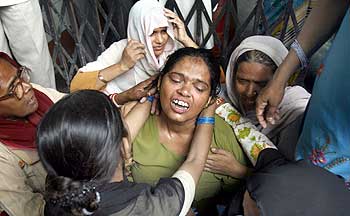 Relatives console Shamsiran Begum (centre), mother of Afroz, a school girl killed in the stampede.