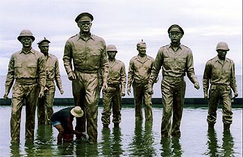 A Filipino worker cleans General MacArthur's statue