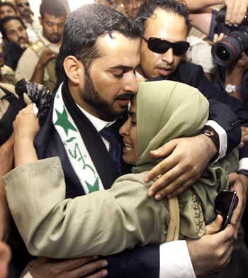 Muntazer al-Zaidi embraces his sister upon arrival at the Al-Baghdadya television station following his release from prison in Baghdad