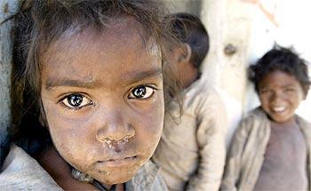 Tribal children stand outside their house at Patara village in Madhya Pradesh