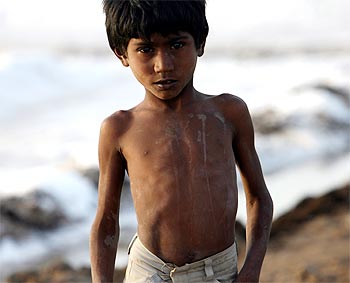 A worker's son poses for a picture at a salt pan near Bhavnagar in Gujarat
