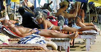 Tourists relax at the Baga beach in Goa