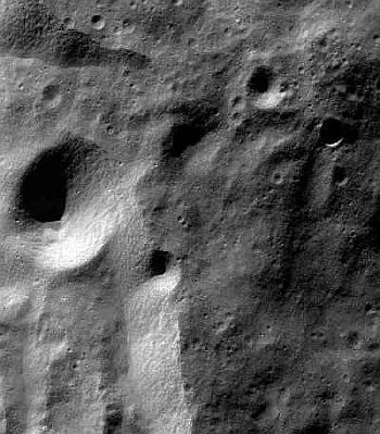 An image of the moon's surface, taken from the lunar orbit by Chandrayaan-1 spacecraft's Terrain Mapping Camera, shows many large and numerous small craters. The bright terrain on the lower left is the rim of the 117-km wide Moretus crater.