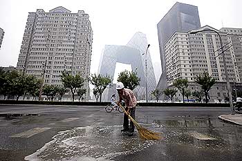 A worker sweeps water off a Beijing street
