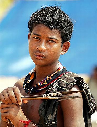 A tribal teenager holds a bow and arrows at a relief camp in Dharbaguda